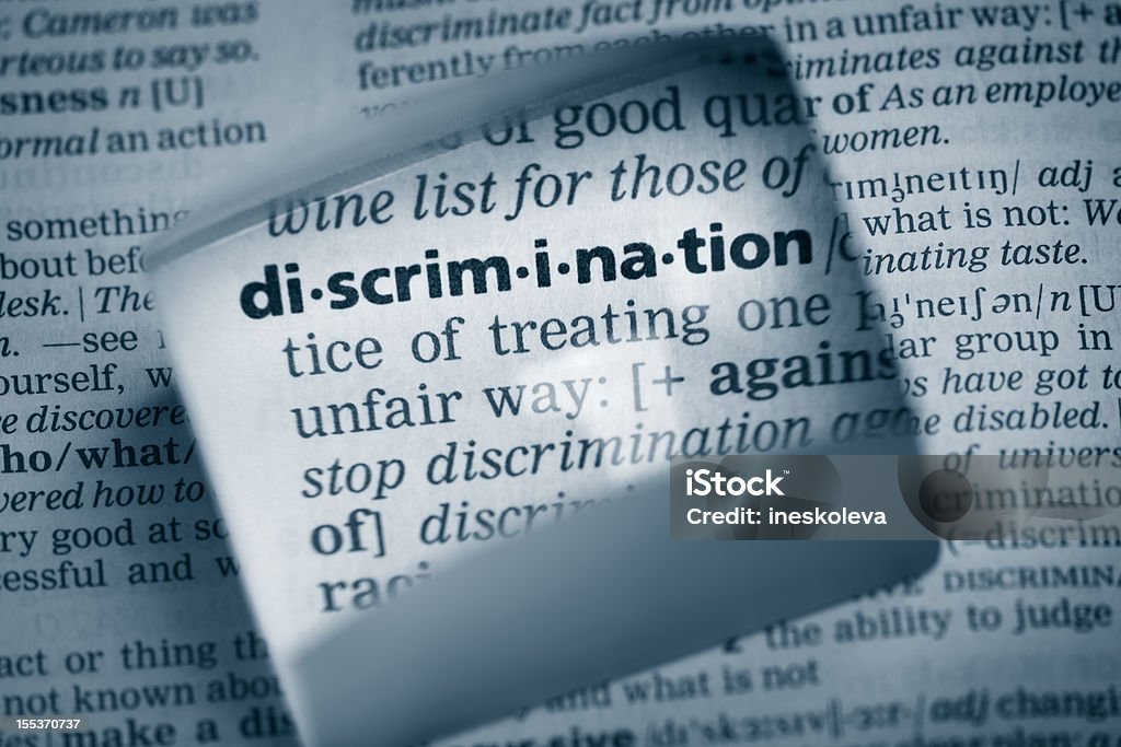 Definition "discrimination" The Dictionary definition of the word “discrimination” photo taken through magnifying glass from a page of a dictionary with selective focus. Racism Stock Photo