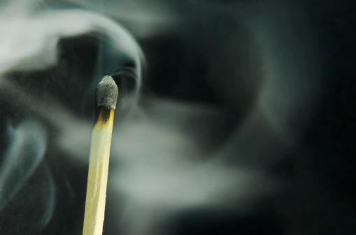 Smoke coming from an extinguished wood match. Black background ... Copy space. 