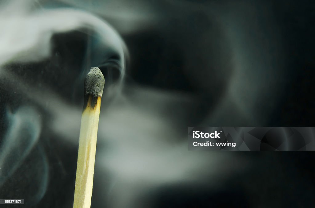 Smoking Match  ... Copy Space Smoke coming from an extinguished wood match. Black background ... Copy space.  Mental Burnout Stock Photo