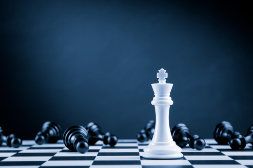 Ajedrez en el tablero blanco King entre acostado sobre chessboard pawns negro photo