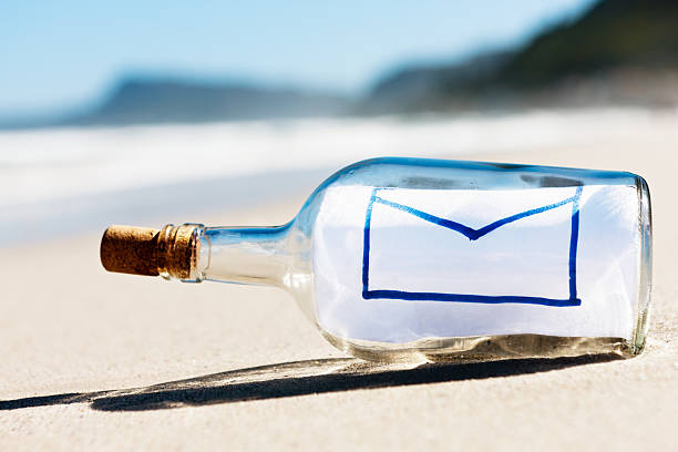 エンベロップ e メールメッセージのアイコンはボトルで空のビーチ - message in a bottle beached bottle desert island ストックフォトと画像