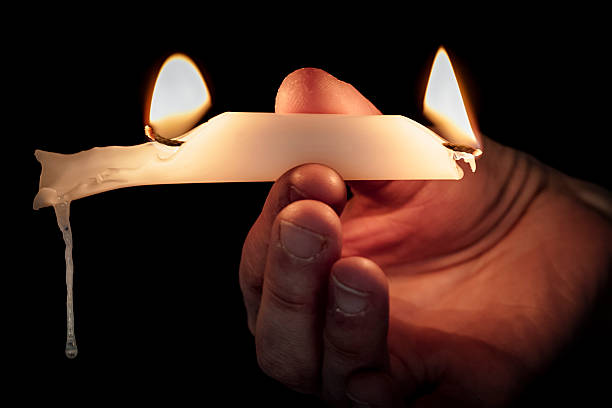 burning the candle at both ends - alight candle stock-fotos und bilder