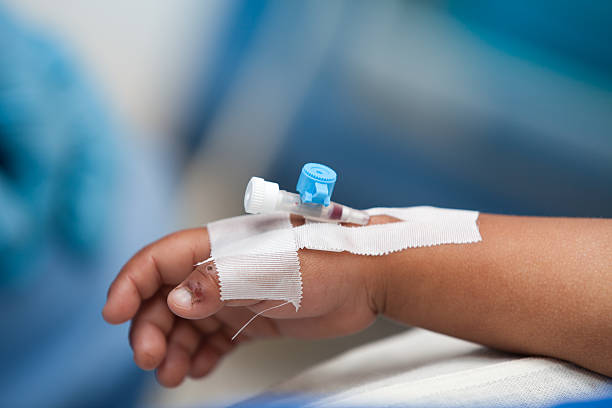 Close-up of child's hand undergoing IV blood transfusion stock photo