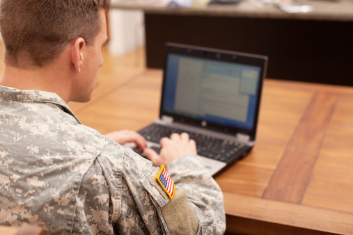 American soldier trabajando en la computadora portátil photo