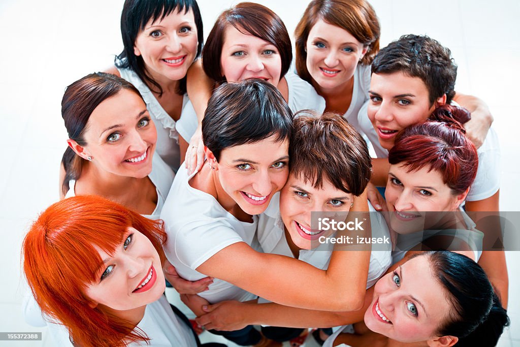 Cheerful friends Group of women standing together, looking up at the camera and smiling. Elevated view. Adult Stock Photo