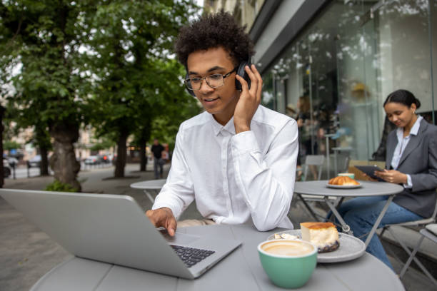 istock Young businessman with headphones working remotely and looking contented 1553725129