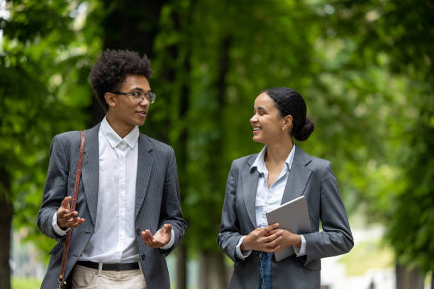 istock Colleagues walking in the park during the break and discussing business issues 1553725178