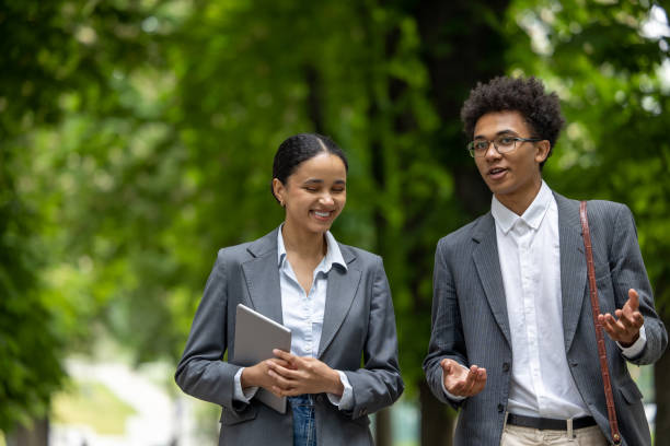 istock Colleagues walking in the park during the break and discussing business issues 1553725180