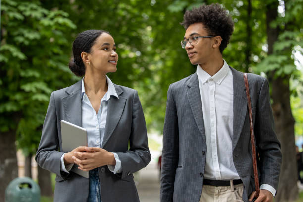 istock Colleagues walking in the park during the break and discussing business issues 1553725195