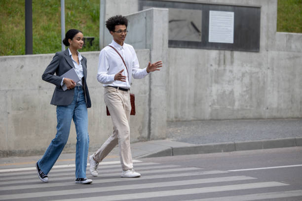 istock Young couple talking and crossing the street 1553726842
