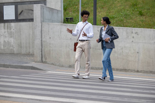 istock Young couple talking and crossing the street 1553726848