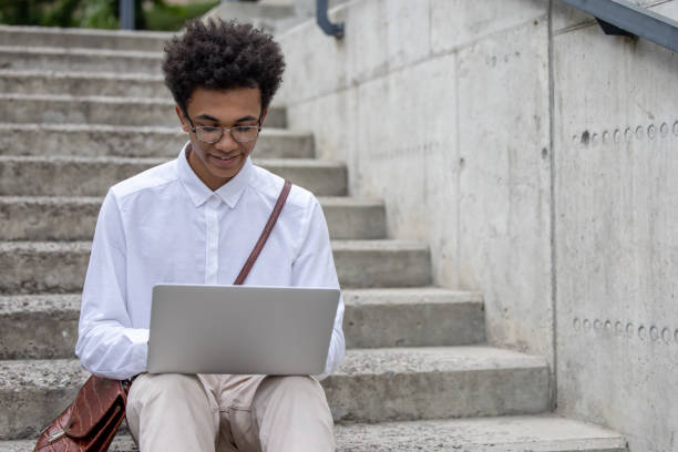 istock Curly-haired young digital nomad working outside and looking happy 1553726859