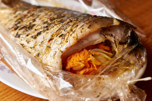 istock Stuffed fish with spices baked in a baking bag. Cooked seafood dishes. 1553730249