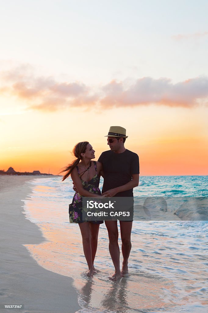 Casal após a caminhar ao longo da praia ao pôr do sol - Royalty-free Praia Foto de stock