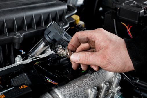 Mechanic checks the ignition plugs of a modern car
