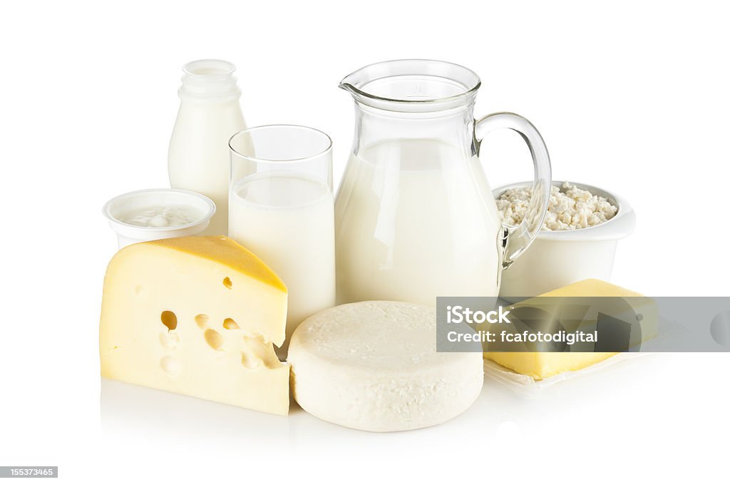 Assortment of most common dairy products on white backdrop Image of dairy products shot on reflective white backdrop. Includes: milk, various types of cheese, butter, ricotta, milk cream and yogurt. A milk pitcher and a glass of milk are in the center while the rest of the products are around them. A soft shadow is visible in the foreground. The predominant color is white. DSRL studio shot with Canon EOS 5D Mk II   Dairy Product Stock Photo