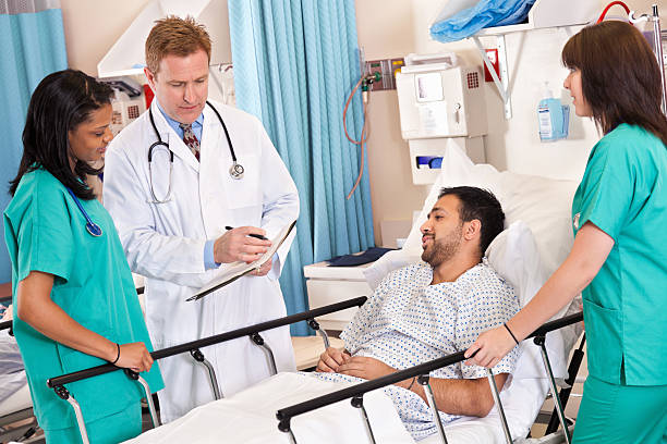 istock Doctor and nurses discussing situation with recovering patient 155373509