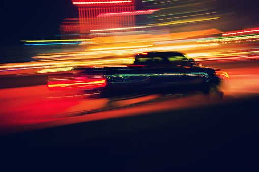 heavy motion blur of a pick-up truck speeding on the city at night