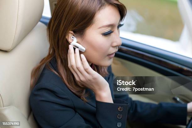 Bellissima Giovane Donna Guida Auto Parlando Su Cuffie Bluetooth - Fotografie stock e altre immagini di Abbigliamento casual