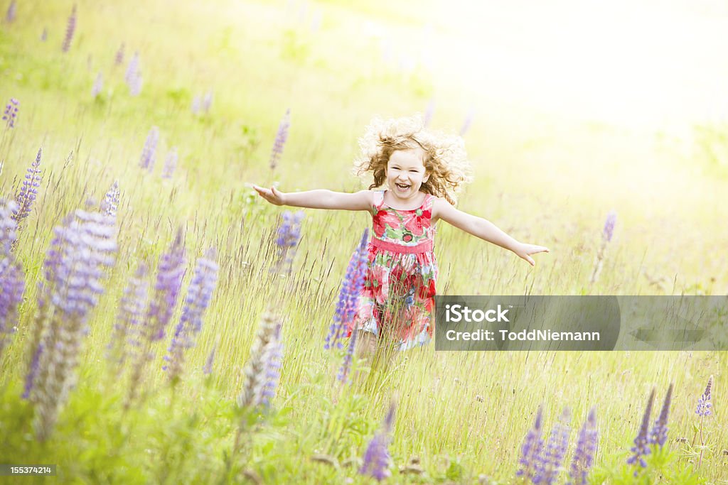 Belle fille courir à travers champ avec fleur. - Photo de 2-3 ans libre de droits