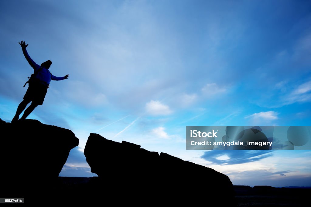 silhouette uomo con le braccia sollevate al Cielo variabile - Foto stock royalty-free di Adulto