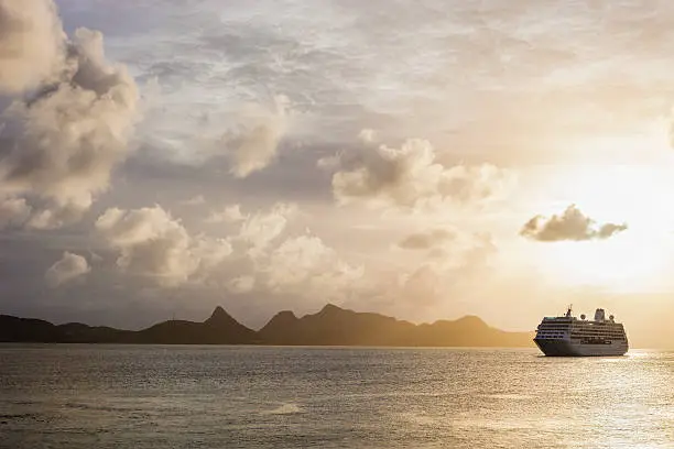 Photo of Sunset over the sea with a cruise ship in Grenadines