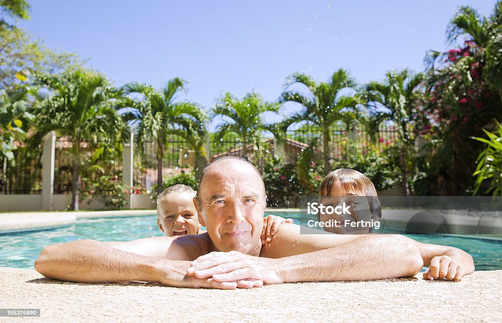 Playing with Grandad A photograph of grandfather with his grandchildren in a swimming pool. Grandchild Stock Photo