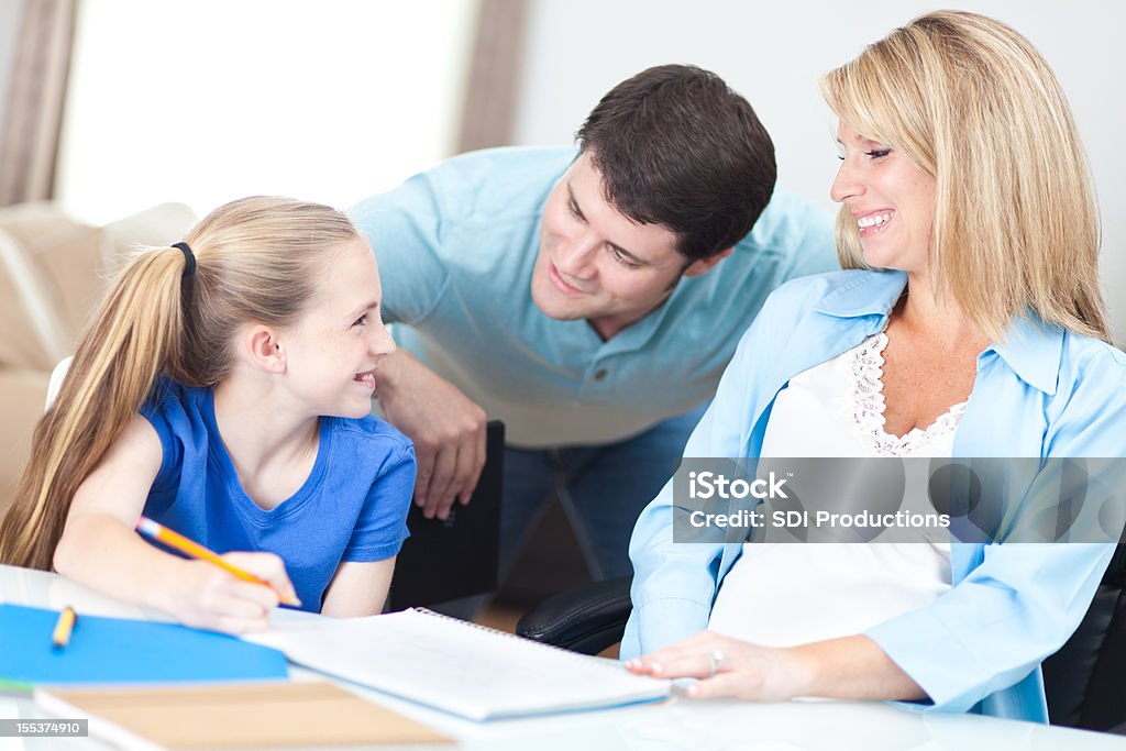 Mère et père aider fille avec son schoolwork - Photo de Adulte libre de droits