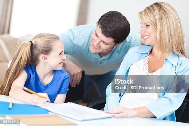 Mãe E Pai Ajudando Sua Filha Com Schoolwork - Fotografias de stock e mais imagens de Adulto - Adulto, Aluna, Aluno da Escola Primária