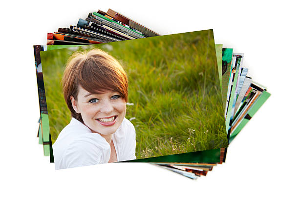 Stack of holiday photographs on white stack of paperphotographs on white background with a beauty smiling dark hair teenager on the first image printout photos stock pictures, royalty-free photos & images