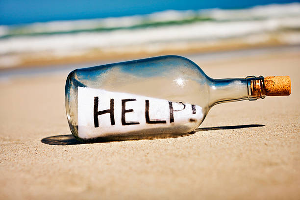 help says frantic message in bottle on deserted beach - onbewoond eiland stockfoto's en -beelden