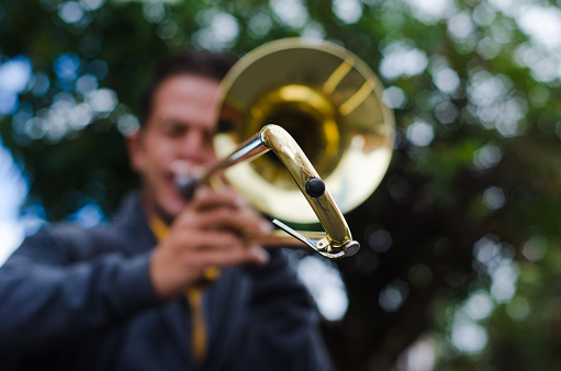 defocused Street musician playing trombone and copy space