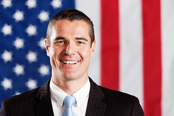 istock Handsome man smiling in front of American flag 155375371