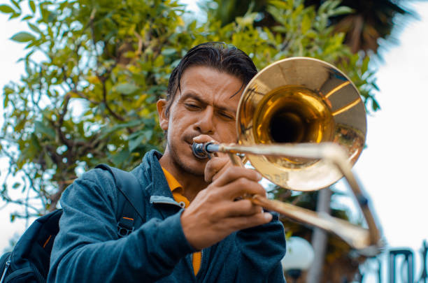 Street musician playing trombone and copy space stock photo