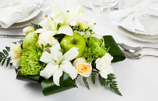 A beautiful white floral arrangement on a venue table