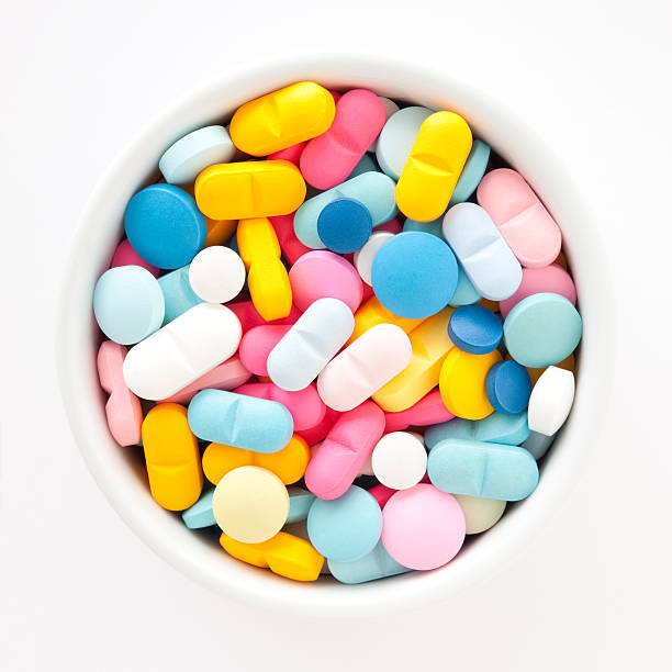 Multicolored pills Pills in white bowl dependency photos stock pictures, royalty-free photos & images