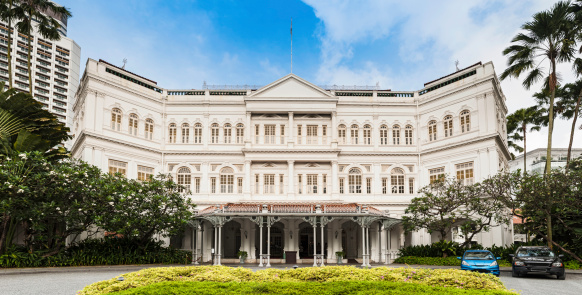 The imposing ornate Victorian facade of the 19th Century Raffles Hotel, iconic symbol of luxury and birthplace of the Singapore Sling cocktail. ProPhoto RGB profile for maximum color fidelity and gamut.