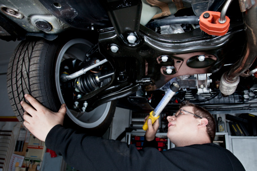 Mecánico está revisando Los amortiguadores de un coche moderno photo