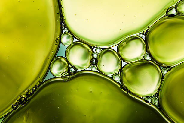 Oil & Water - Abstract Background Green Macro 2.5:1 macro photography of oil and water. cooking oil photos stock pictures, royalty-free photos & images