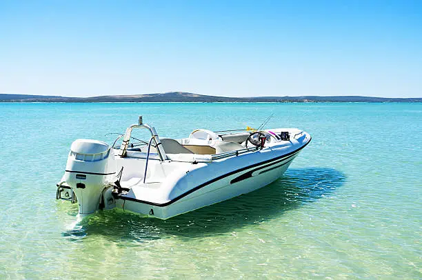 A motor boat moored in the beautiful turquoise waters of the lagoon at Langebaan on the west coast of South Africa, 100km north of Cape Town.