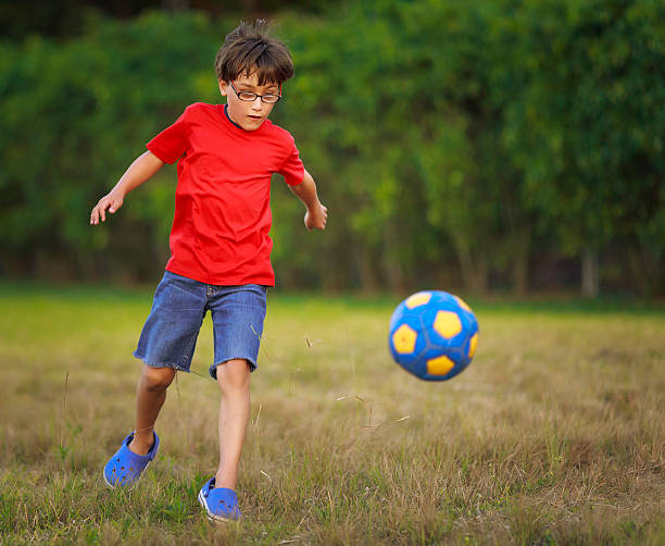 istock boy playing with a soccer ball 155375821
