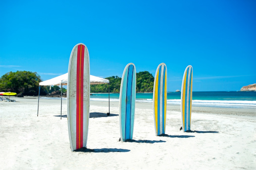 Surfboards on a beach in Jaco Costa Rica, beach, The pacific coast. Rainforest sits in the Background ground. 