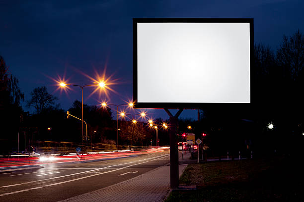 Blank advertising billboard on city street at night