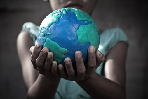 Young poverty girl holding the earth.