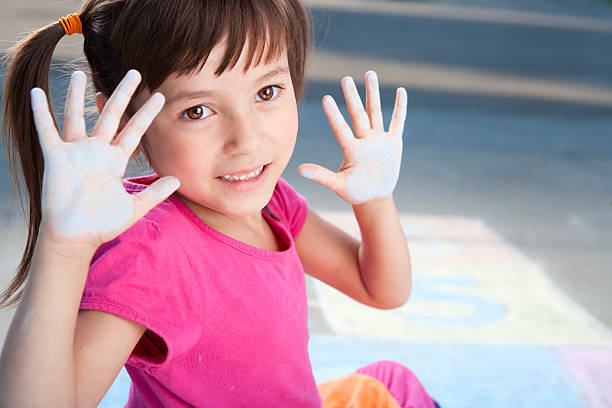 istock Young girl sitting and playing with chalk 155376913