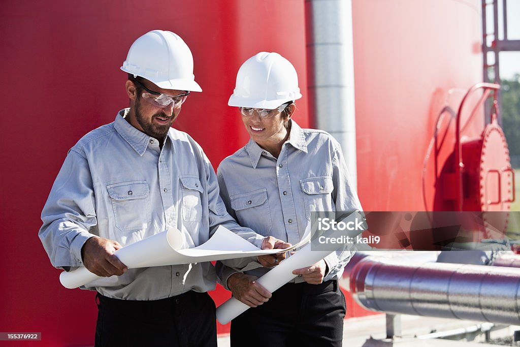 Arbeiter stehend von industriellen water tower mit Plänen - Lizenzfrei Helm Stock-Foto