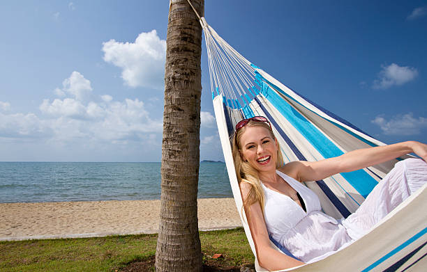 istock Beautiful woman in a hammock by the beach 155377460