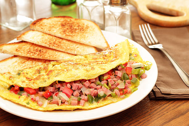 istock Omelet and white toast on a plate on a wooden table 155377744
