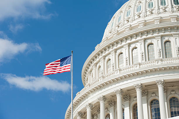 american flag waving in front of capitol hill - overheid stockfoto's en -beelden