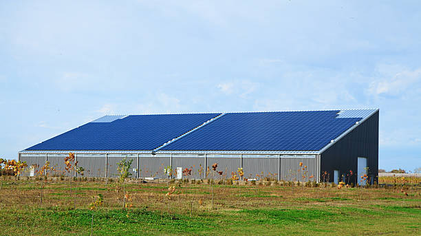 nouvelle grange avec des panneaux solaires sur le toit - batiment agricole photos et images de collection